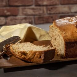 Banana Bread loaf baked to a golden crust and placed on a wood tray Roma & Alma Photography Banana Bread
