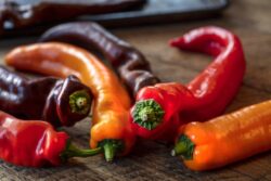 Colorul Poivron peppers being prepped on a wood table for roasting in the oven