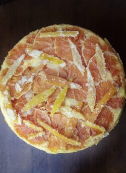Candied Orange Upside down cake made with orange and lemon rinds on a white creamic plate
