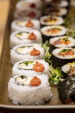 Cut up Sushi Rolls trimed with flowers and radish roots filled with crab meat and tuna