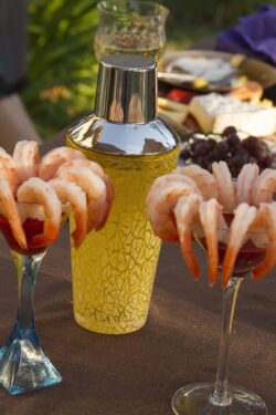 Shrimp cocktail on martinin glasses with cocktail shaker in the background