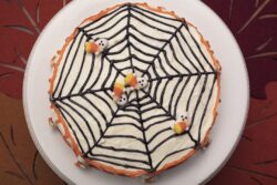 White frosting Hallowen cake with orange and black icing and candy ghosts