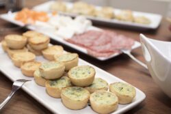 Mini spinach and cheese quiche served with other cold cut appetizers for a party gathering