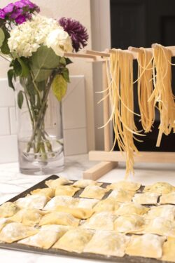 Homemade Spaghetti Drying on a Pasta Rack and Ravioli Ready to be cooked
