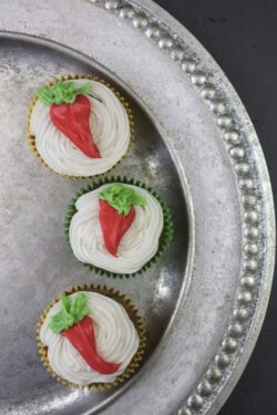 Sweet carrot cupcakes make with white cream cheese frosting and trimmed with orange and yellow carrot design