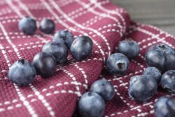 Grouping of blueberries on a folded dish towel on a rustic table