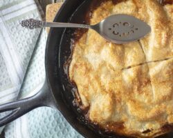 Apple pie baked in a cast iron skillet with a butter caramel sauce and golden crust Golden Crusted Apple Pie