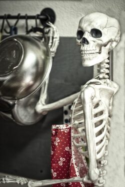 Scary Halloween skeleton in the kitchen getting ready to prepare food for the holiday