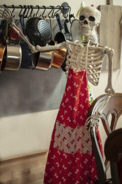 Scary Halloween skeleton in the kitchen getting ready to prepare food for the holiday