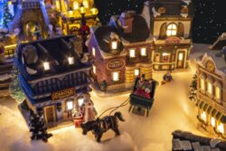 Miniature Christmas village scene with houses, trees, people, dogs and cats celebrating the holidays