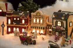 Miniature Christmas village scene with houses, trees, people, dogs and cats celebrating the holidays
