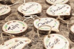 Homemade Christmas tree decoration made from tree trunk and branches with names painted on the face of the wood